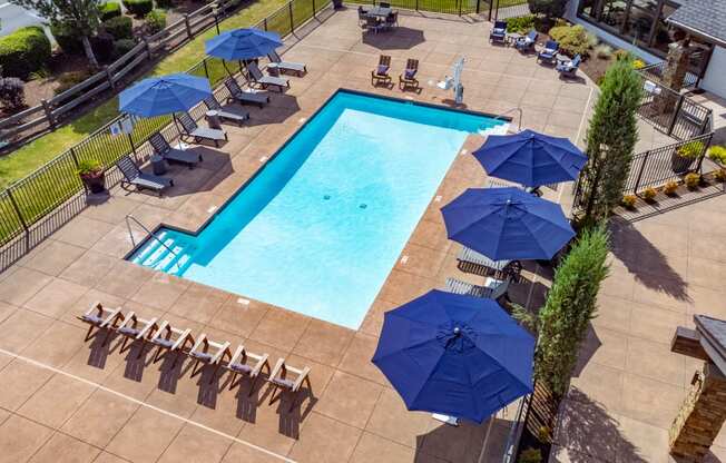 a swimming pool with umbrellas and chairs around it