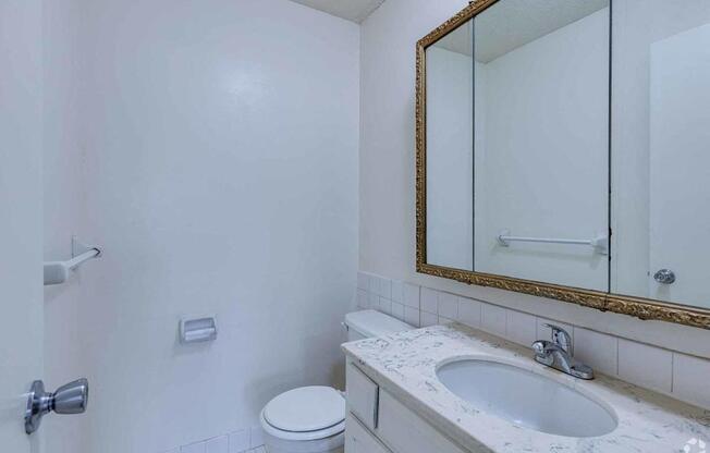 A white toilet sits next to a sink in a bathroom.