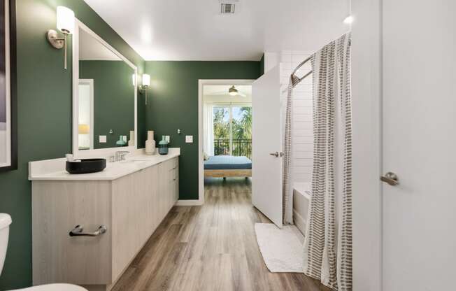 a bathroom with green walls and a shower and a sink