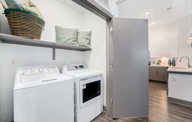 A white washing machine and oven in a modern kitchen.