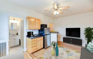 A kitchen with wooden cabinets and a black fridge.