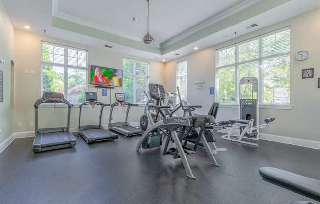 the gym with cardio equipment and windows
