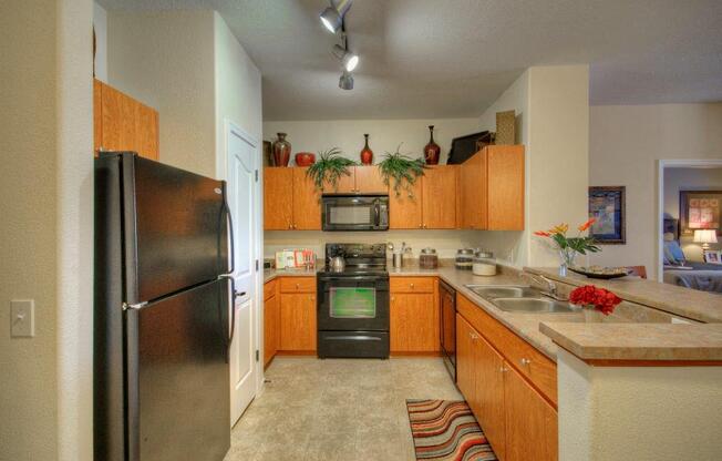 Vue Park West Kitchen with black appliances and brown cabinets