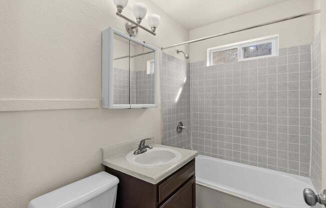 A bathroom with a white toilet, a sink, and a bathtub.