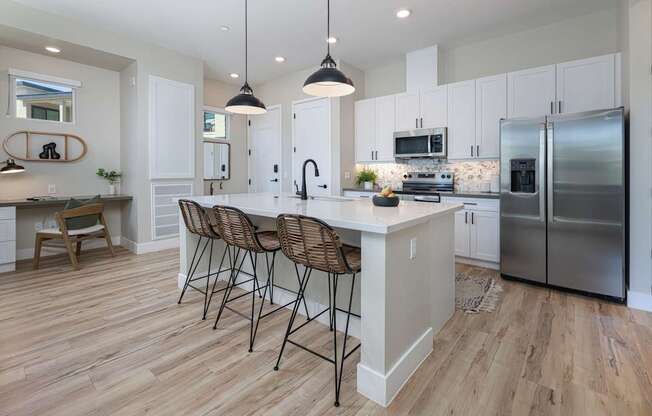 A kitchen with a white island and stainless steel appliances.