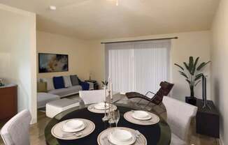 A dining room with a black table set for two.