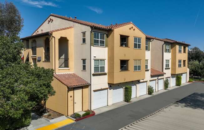 a row of yellow and white apartment buildings on the side of a street