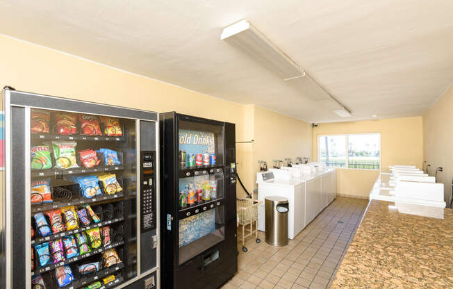 a snack room with two refrigerators and a row of vending machines