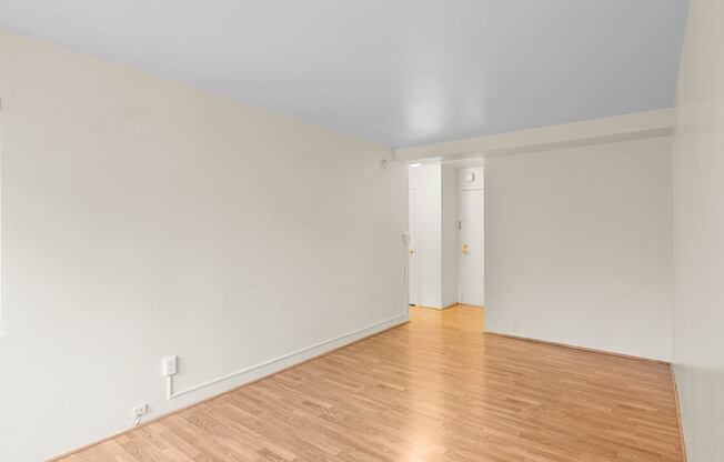 a living room with white walls and wood floors