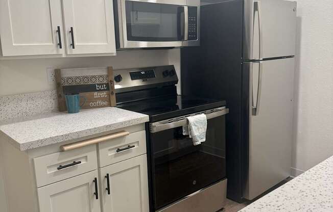 A kitchen with black appliances and white cabinets. at Camino de Oro Apartments, Torrance, CA, 90505