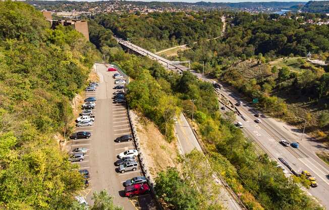 A parking lot with cars is situated on a hillside.
