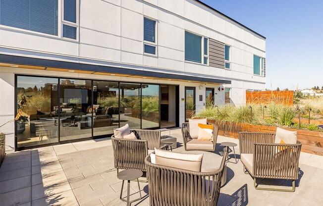 a patio with chairs and a table in front of a building