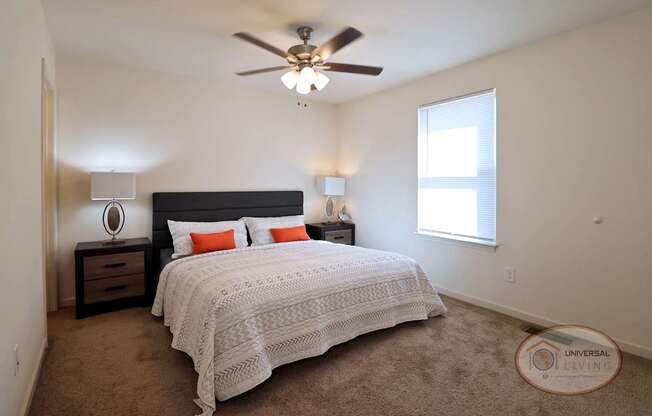 A bedroom with a bed, nightstand, and window.