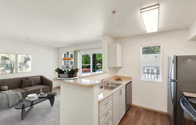 a living room with a couch and a kitchen with a sink