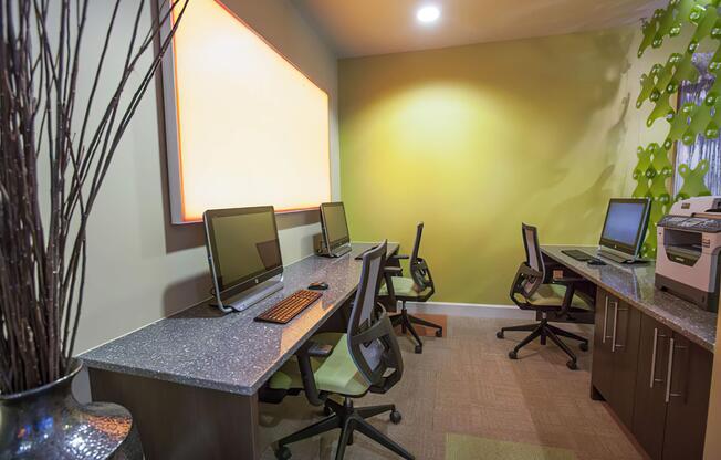 a desk with a computer and a chair in a room