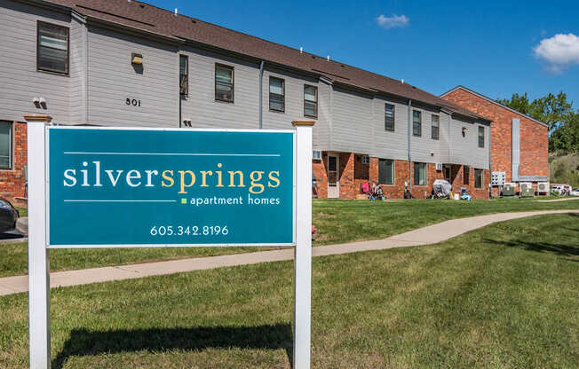 a sign for silver springs apartments in front of a building