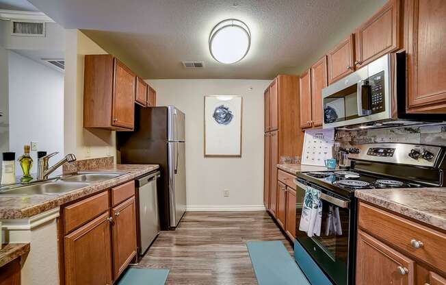 a kitchen with wood cabinets and stainless steel appliances