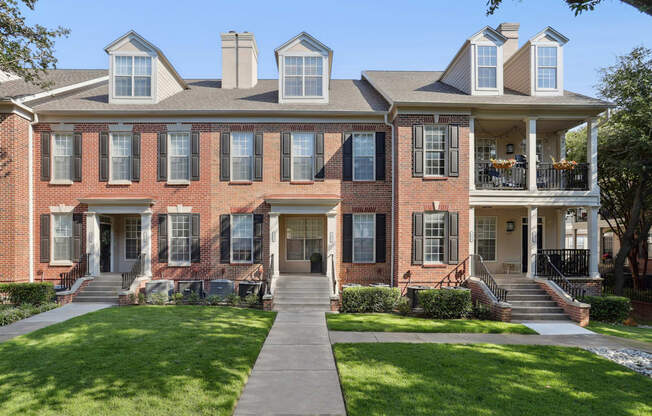 A large red brick house with a white porch.
