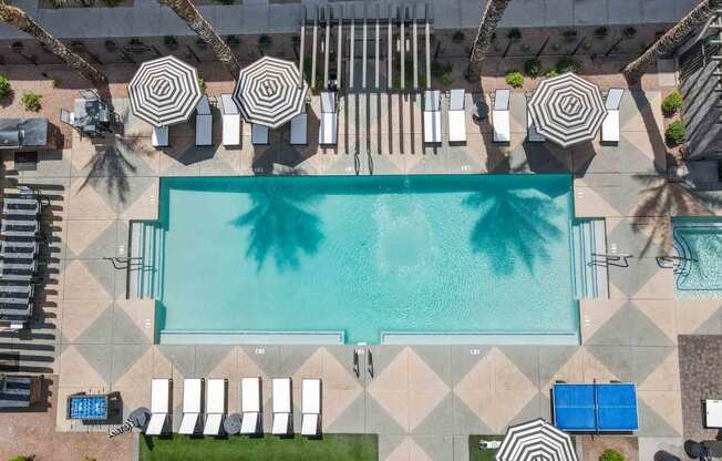 aerial view of a resort pool surrounded by lounge chairs and umbrellas