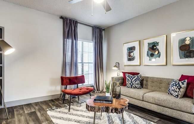 A living room with a couch, chair, and pictures on the wall.