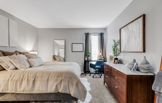 A bedroom with a large bed and a desk with a chair. at The Beacon, Alabama