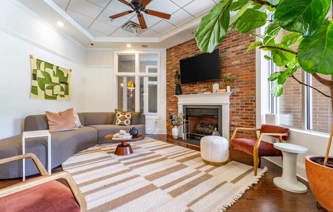 a living room with a brick fireplace and a rug