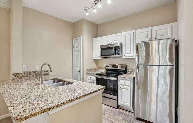 A kitchen with granite countertops and stainless steel appliances.