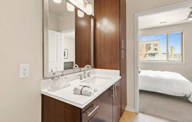 Modern sytle bathroom vanity with marble-look countertops with a view into the bedroom at Sylvan Uptown, Colorado, 80203