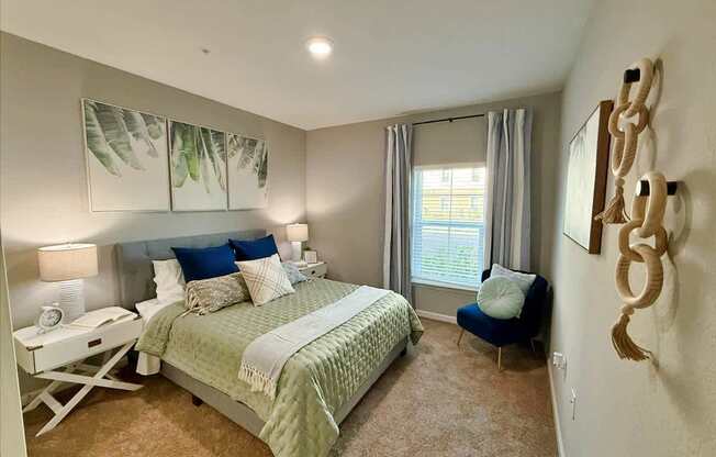 A bedroom with a large bed and a blue chair at flats at sundown luxury apartments in north port fl