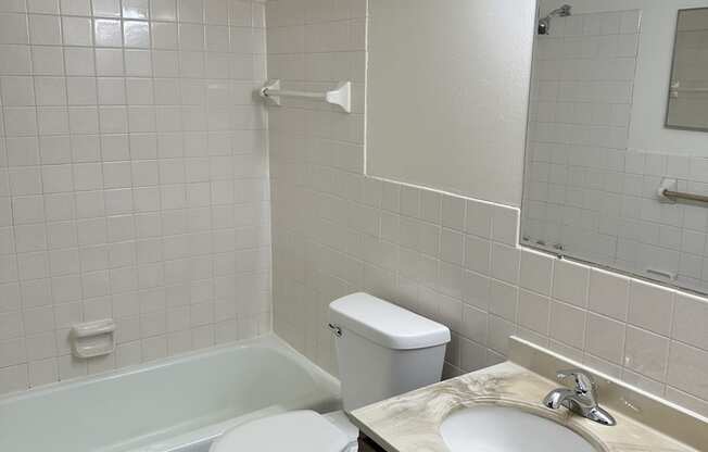 a bathroom with a toilet and a sink and a bath tub