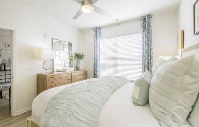 a bedroom with a large bed and a ceiling fan