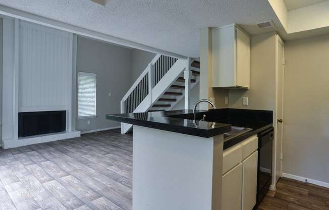 an empty kitchen with a counter top and a staircase