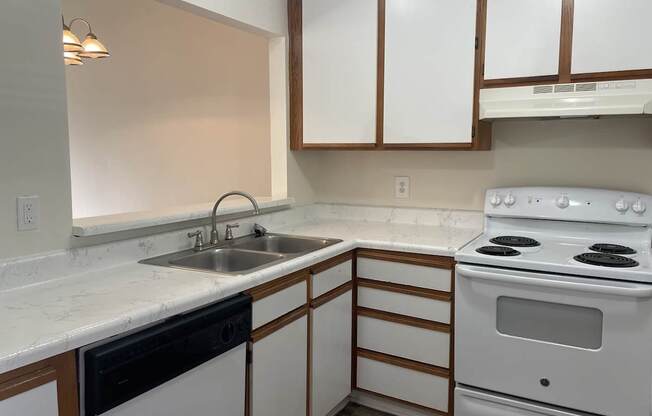 A kitchen with white appliances and wooden cabinets.