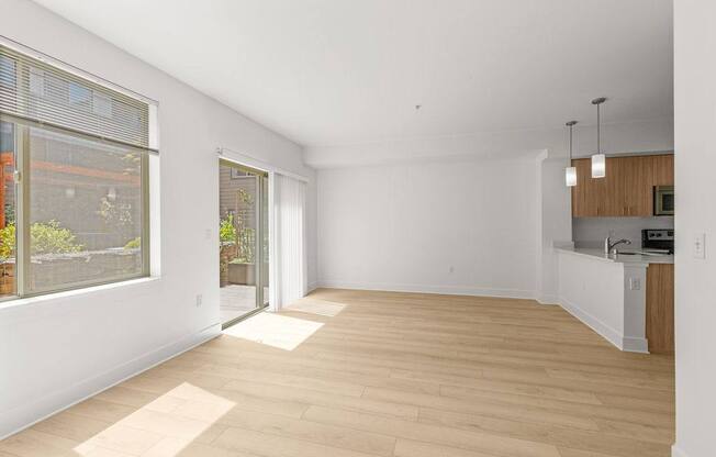 A spacious room with wooden flooring and white walls.