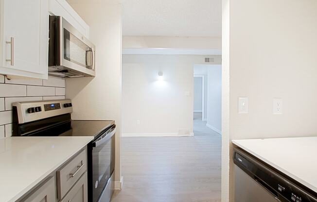 a kitchen with white countertops and stainless steel appliances