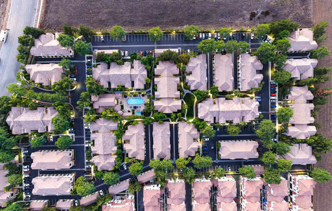 A bird's eye view of a residential area with houses and a pool.