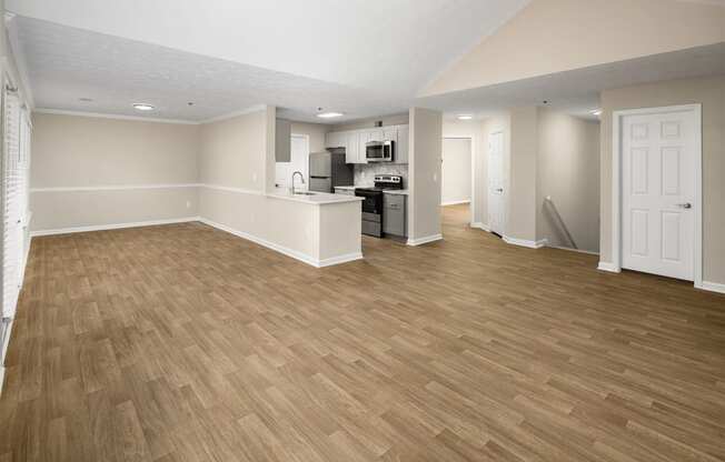 Empty living room with plank-style wood floors.