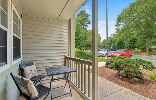 a patio with two chairs and a table on a porch