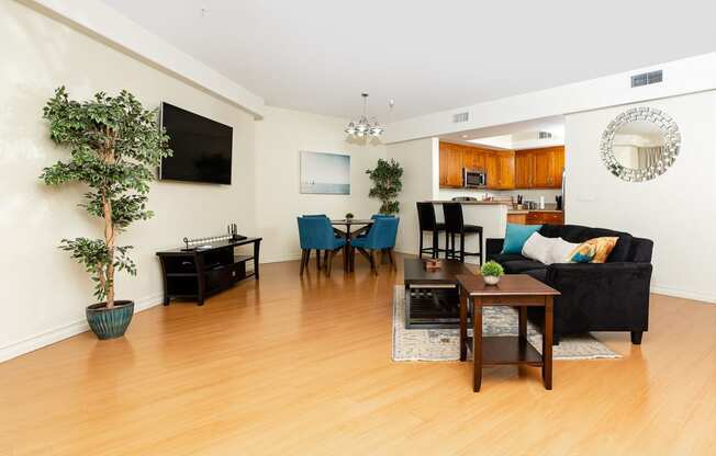 a living room with hardwood floors and a large screen tv on the wall