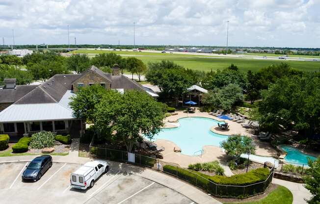 A large swimming pool surrounded by a fence and a grassy area.