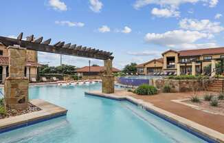 A swimming pool surrounded by lounge chairs at Creekside on Parmer Lane Apartments in Austin, TX