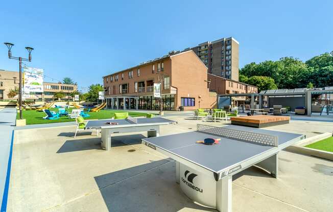 a ping pong table and lounge area are located in the middle of the courtyard