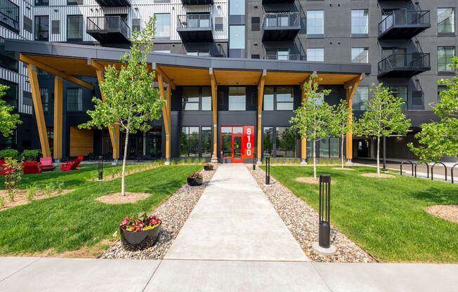 pathway leading to an apartment building with grass and trees