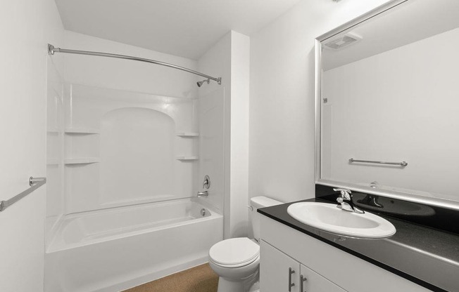 A white bathroom with a toilet, sink, and bathtub.