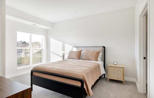 A bedroom with a large bed and a window overlooking a street.