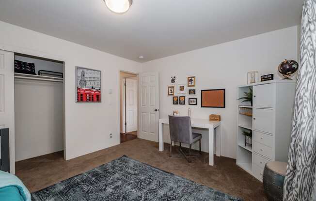 a bedroom with a desk and a closet