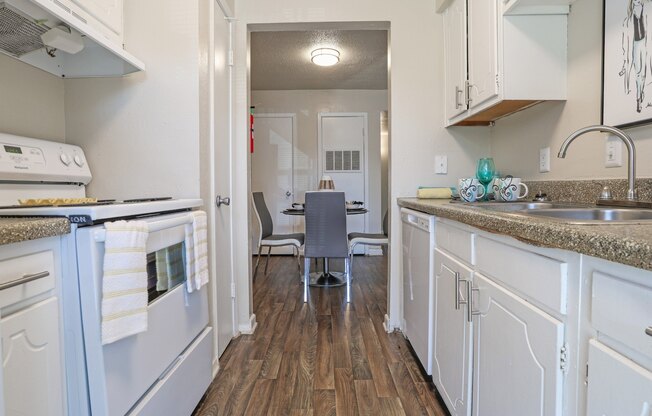 A kitchen with a white stovetop oven and cabinets at The Drake in Bossier City, LA