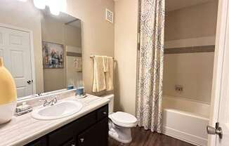 A bathroom with a white sink, toilet, and a white door.