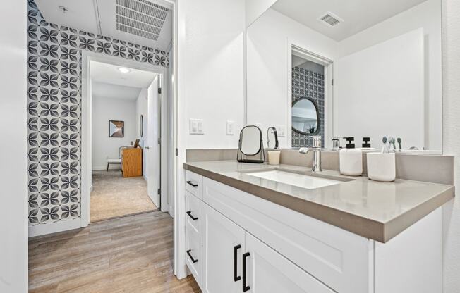 a large white bathroom with a sink and a mirror