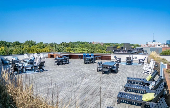 the deck on the top of the building has tables and chairs
